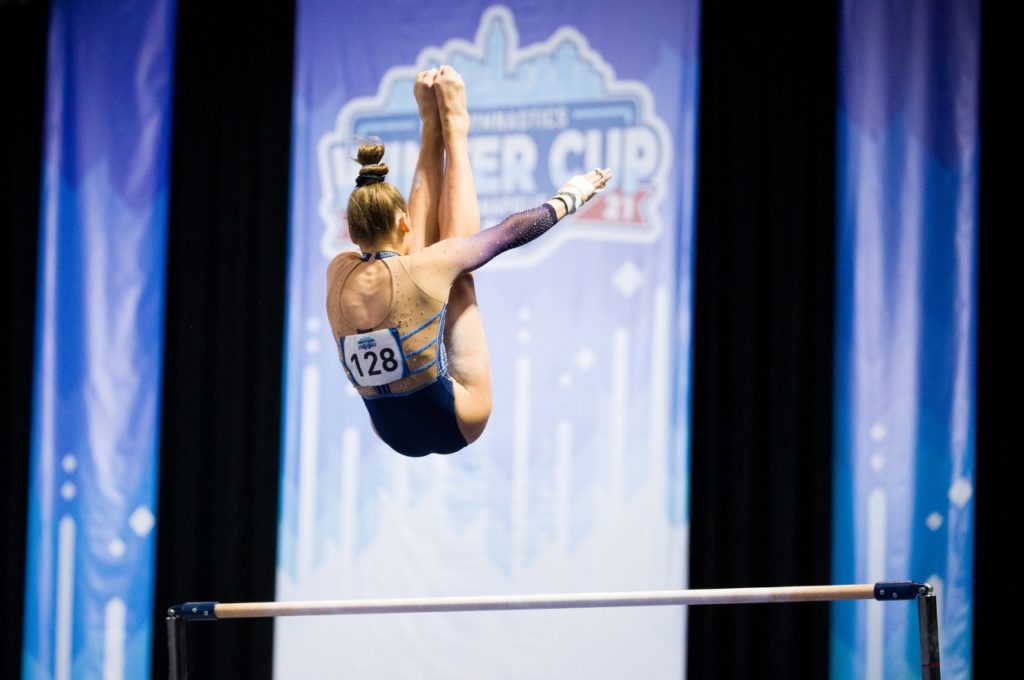 Olivia Greaves performs a release on uneven bars at the 2021 Winter Cup