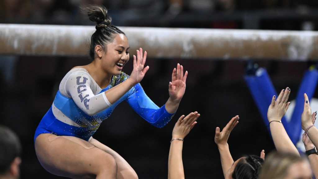 UCLA's Emma Malabuyo celebrates with her teammates after her beam routine during the 2023 Super 16 meet.