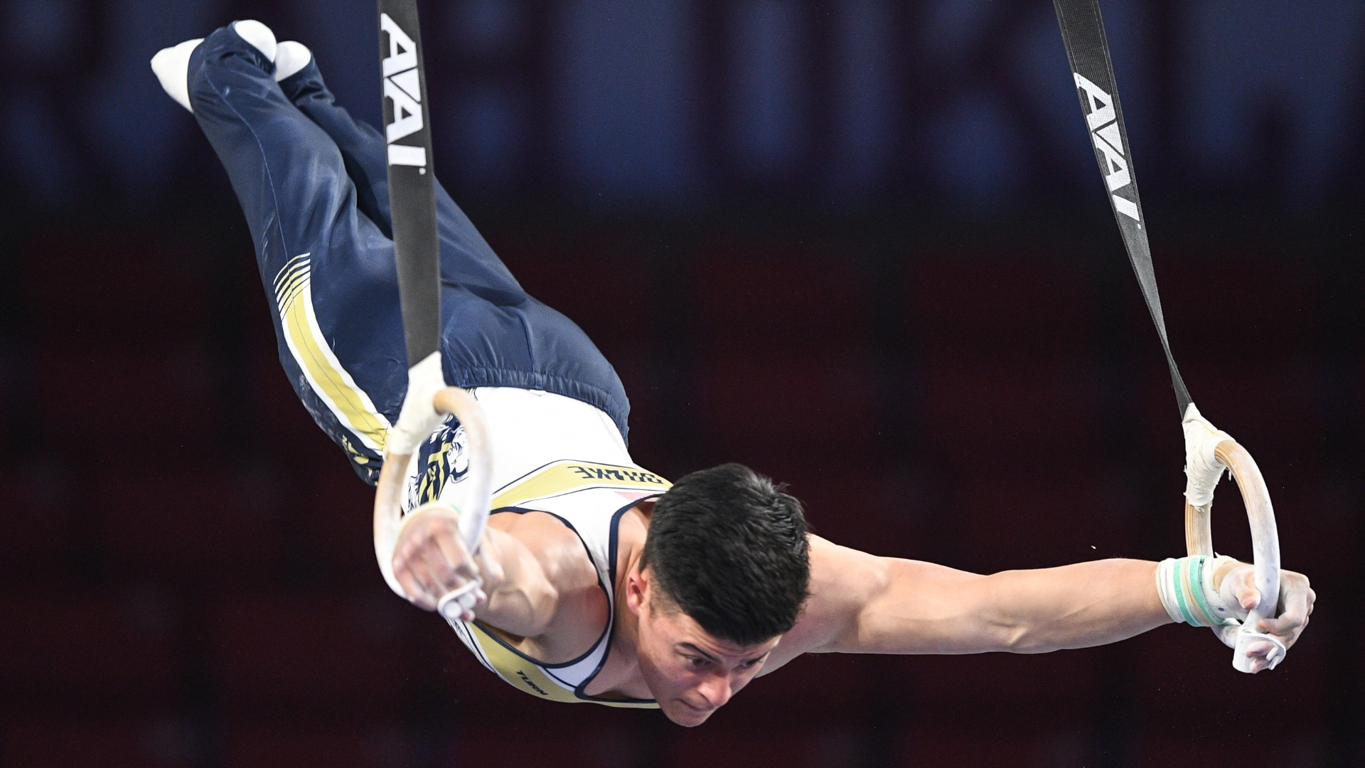 Navy's Isaiah Drake swings on the still rings during the 2022 NCAA Men's Gymnastics Championships.