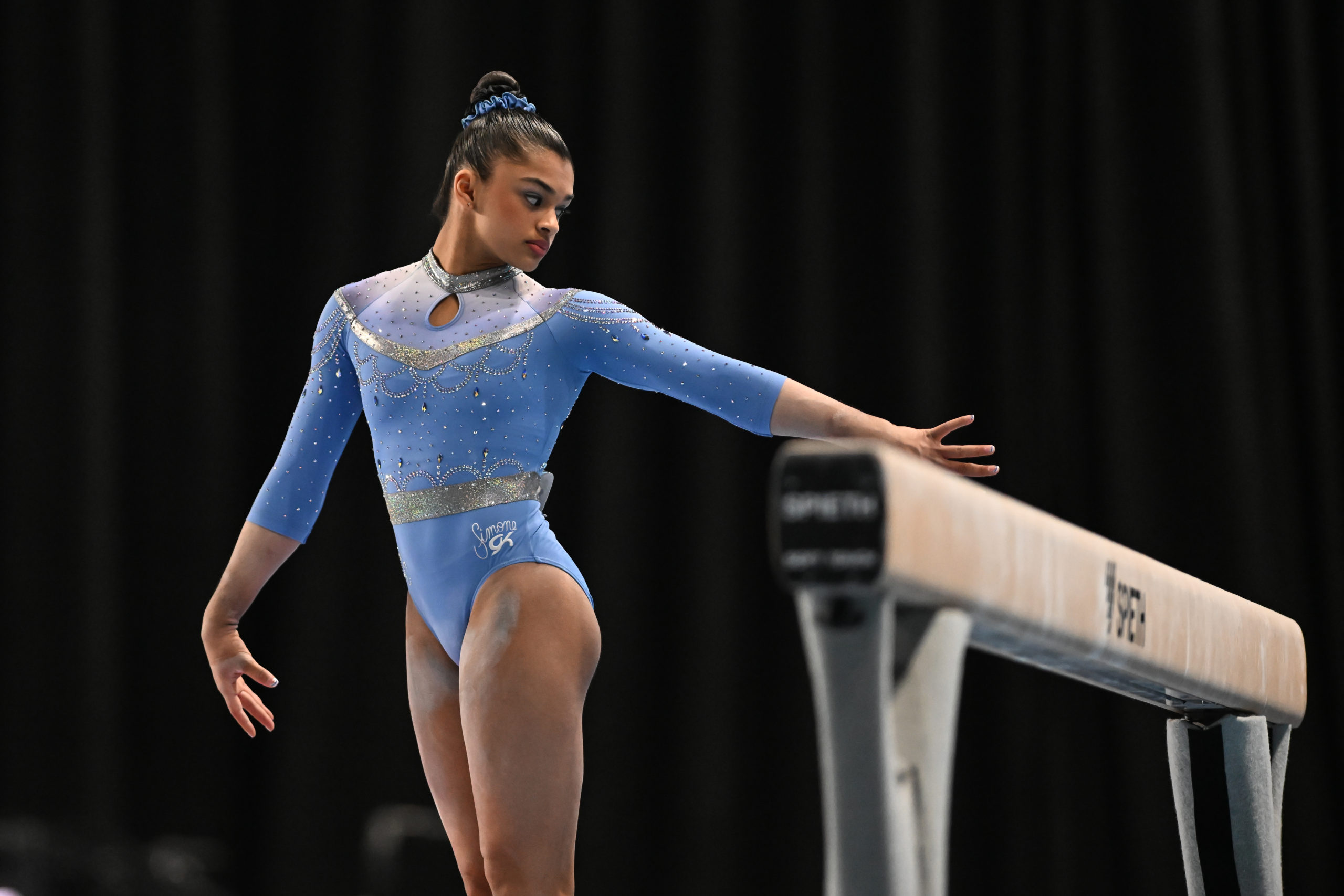 Tiana Sumanasekera (World Champions Centre) spots the beam before mounting the apparatus during the 2023 Winter Cup.