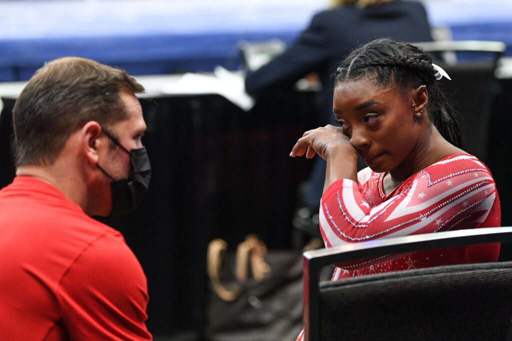 Simone Biles gets emotional while talking with her coach, Laurent Landi, at the 2021 U.S. Gymnastics Olympic Trials.