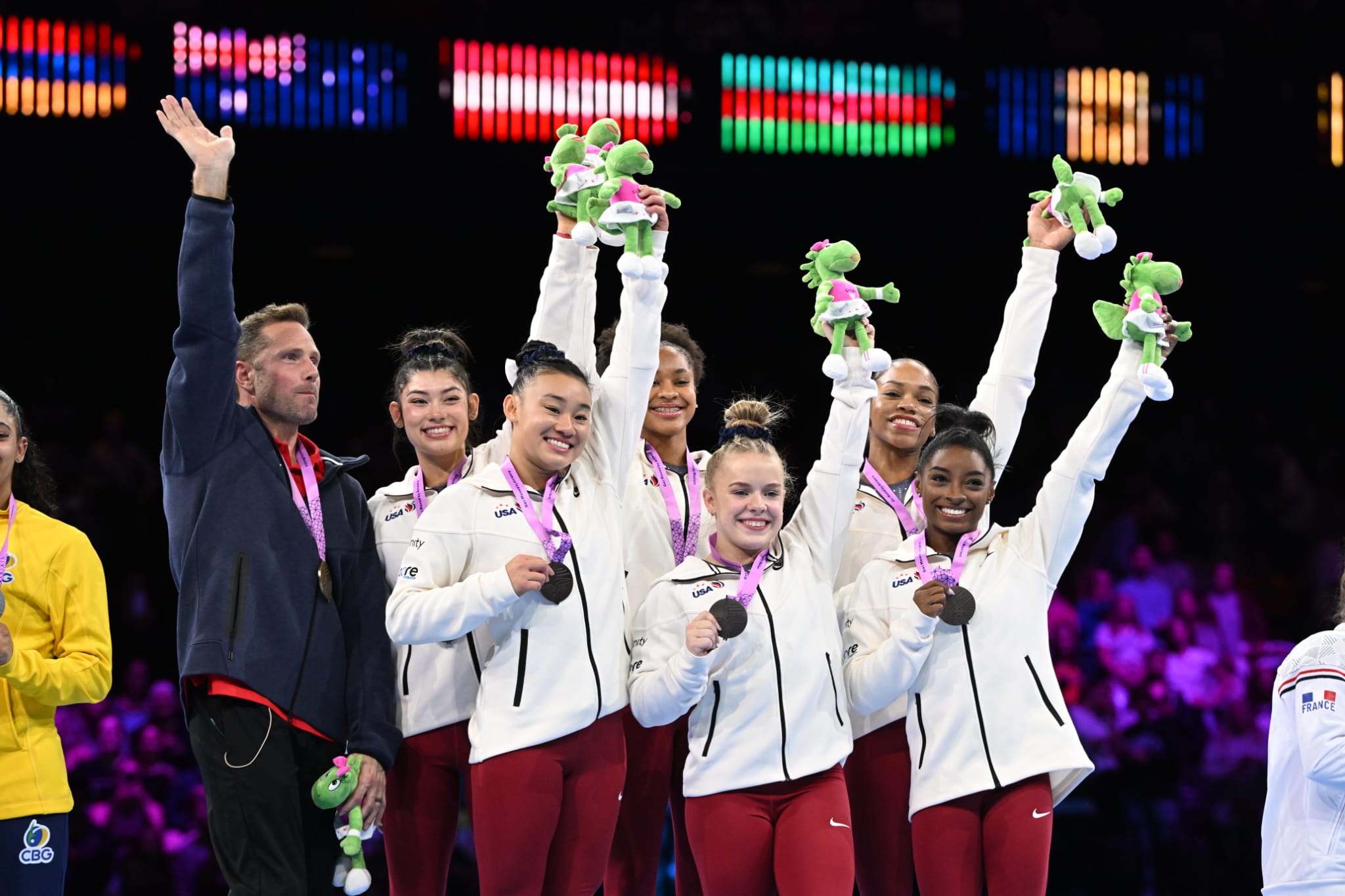 The U.S. women raise their Gymba plushies in celebration after winning team gold at the 2023 World Artistic Gymnastics Championships.
