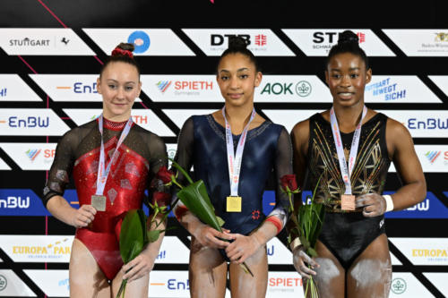 The junior women's uneven bars podium at the 2023 DTB Pokal. From left to right: silver medalist Leire Escauriaza Tipacti (ESP), gold medalist Lilou Viallat (FRA), and bronze medalist Gabrielle Black (CAN). (© Filippo Tomasi)